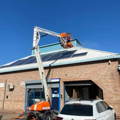 Roofline access work at a brick commercial unit with solar panels
