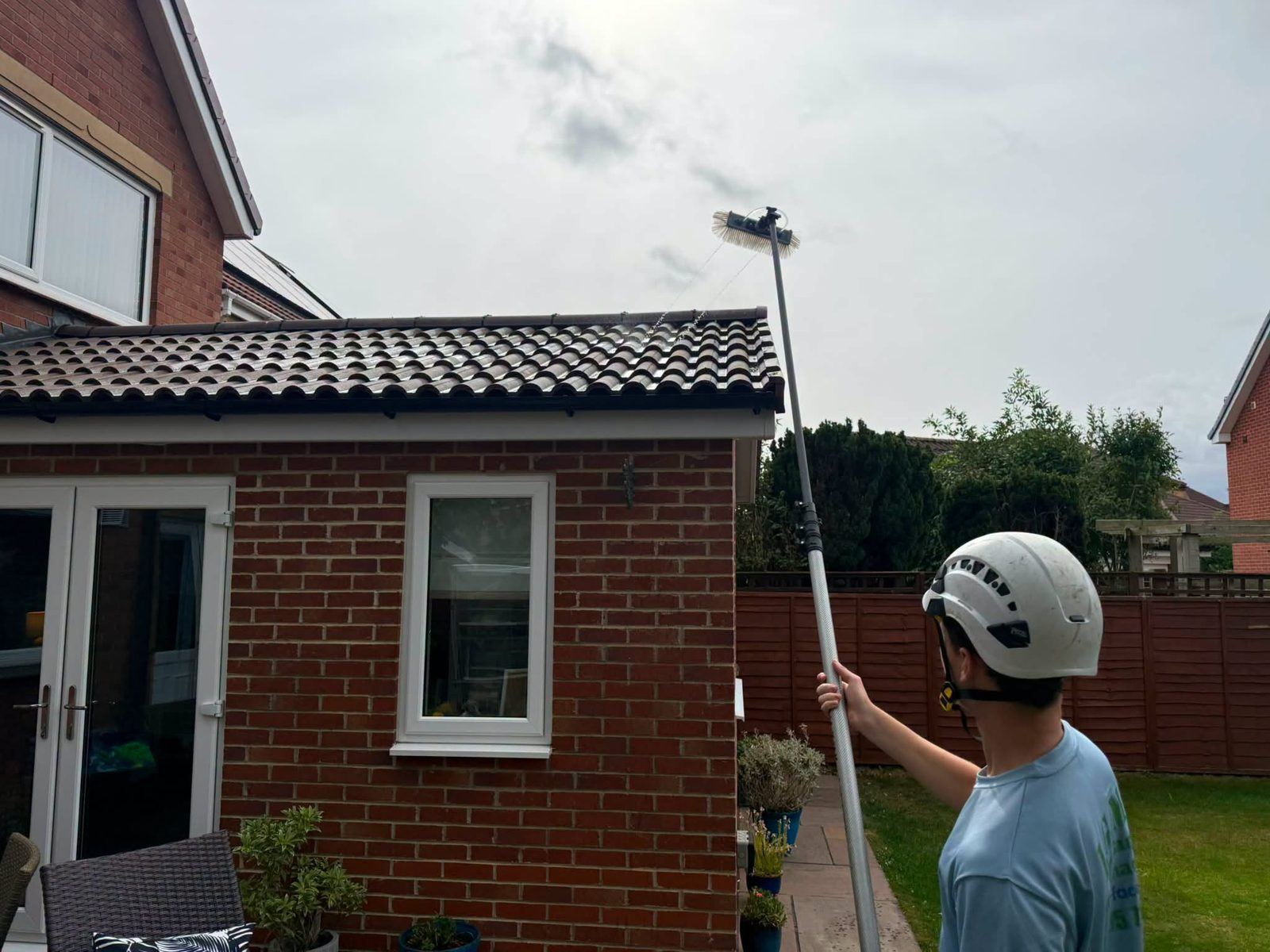 IGM operative cleaning brickwork with a water-fed pole in Teesside